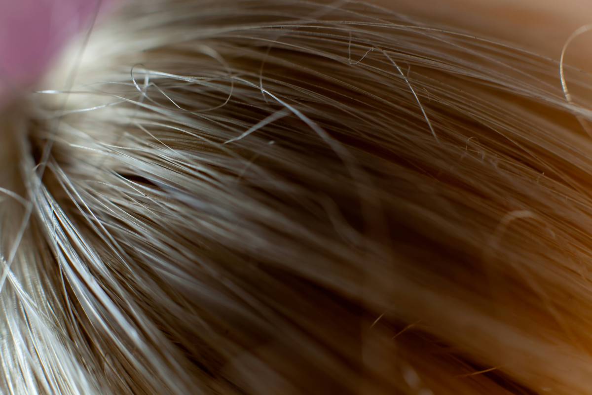 Close-up of hands creating loose hair twists using Gentle Styling technique